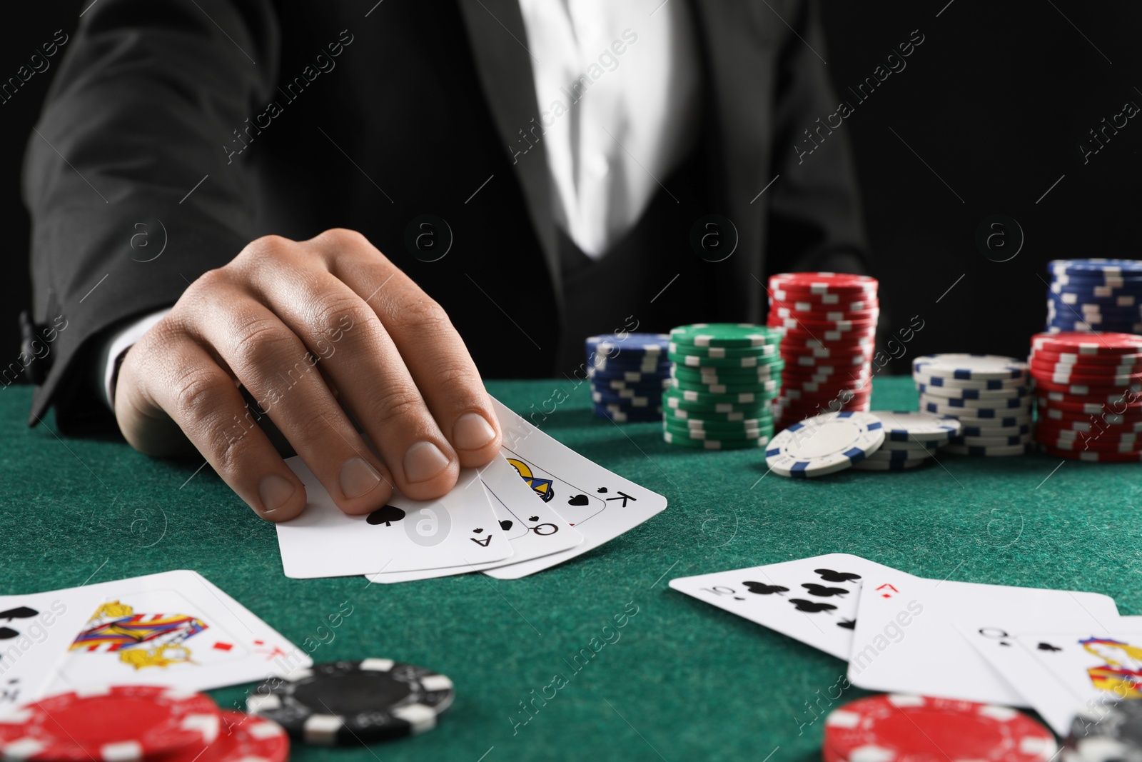 Photo of Man with cards and casino chips playing poker at gambling table, closeup