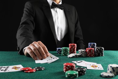 Photo of Man with cards and casino chips playing poker at gambling table, closeup