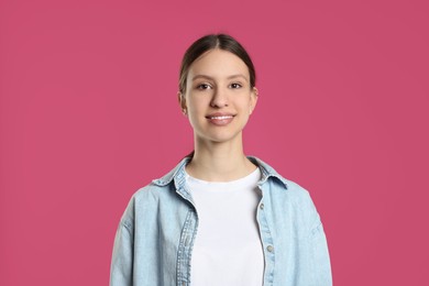 Photo of Portrait of smiling teenage girl on pink background