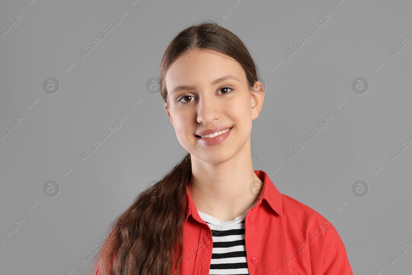 Photo of Portrait of smiling teenage girl on grey background