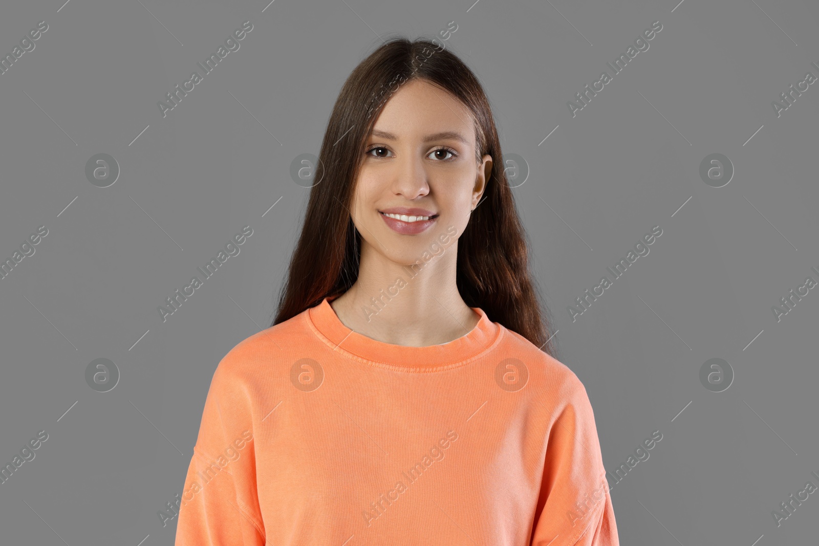 Photo of Portrait of smiling teenage girl on grey background