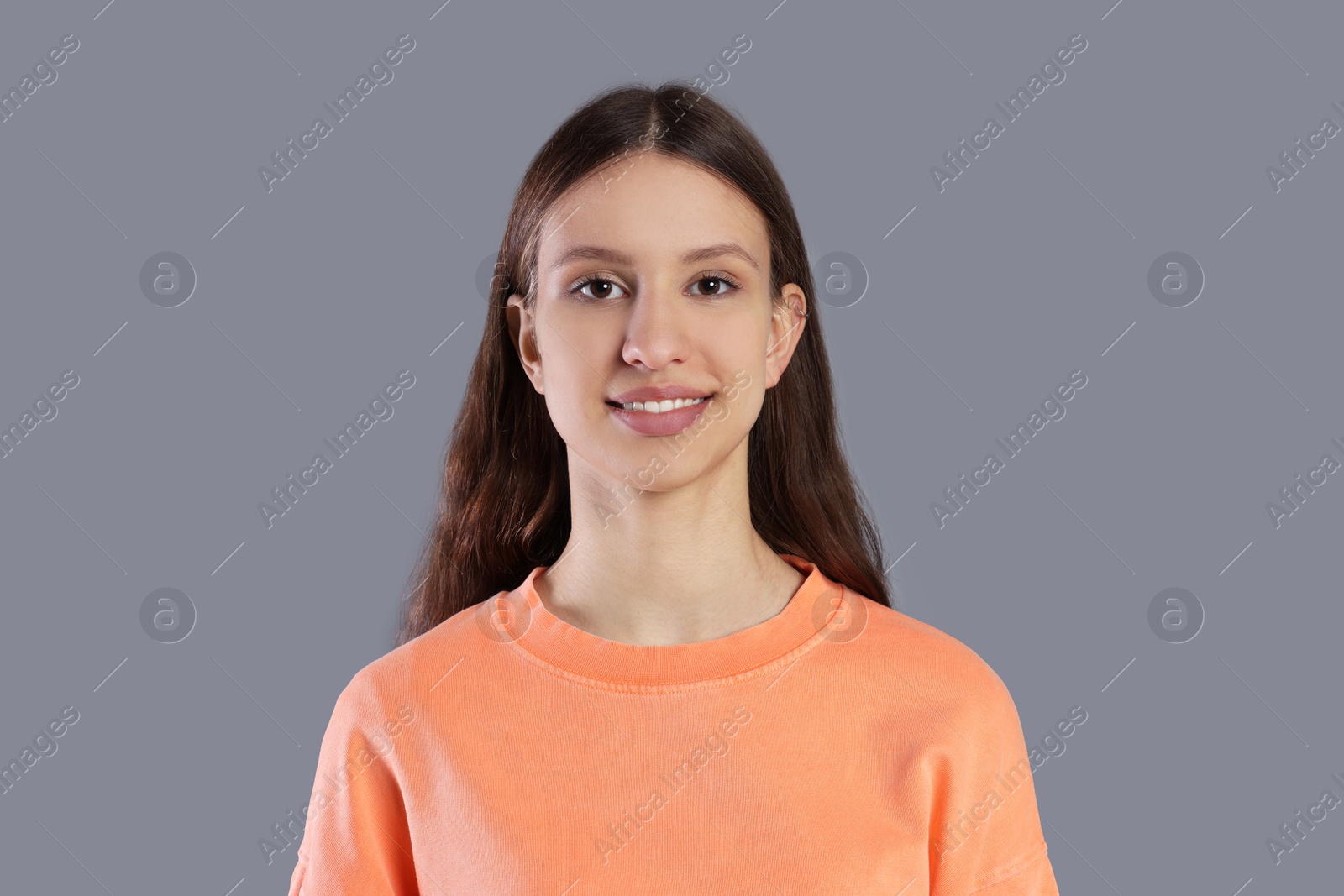 Photo of Portrait of smiling teenage girl on grey background