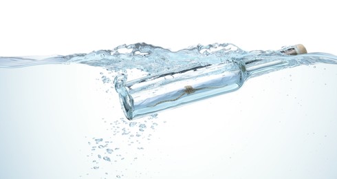 Photo of Corked glass bottle with rolled letter in water on white background