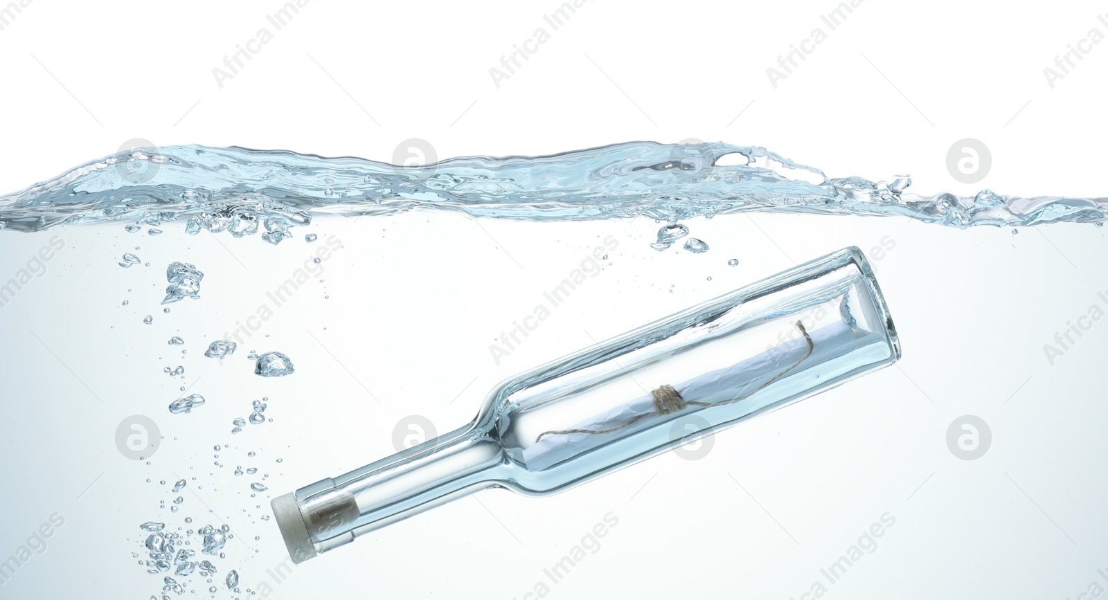 Photo of Corked glass bottle with rolled letter in water on white background