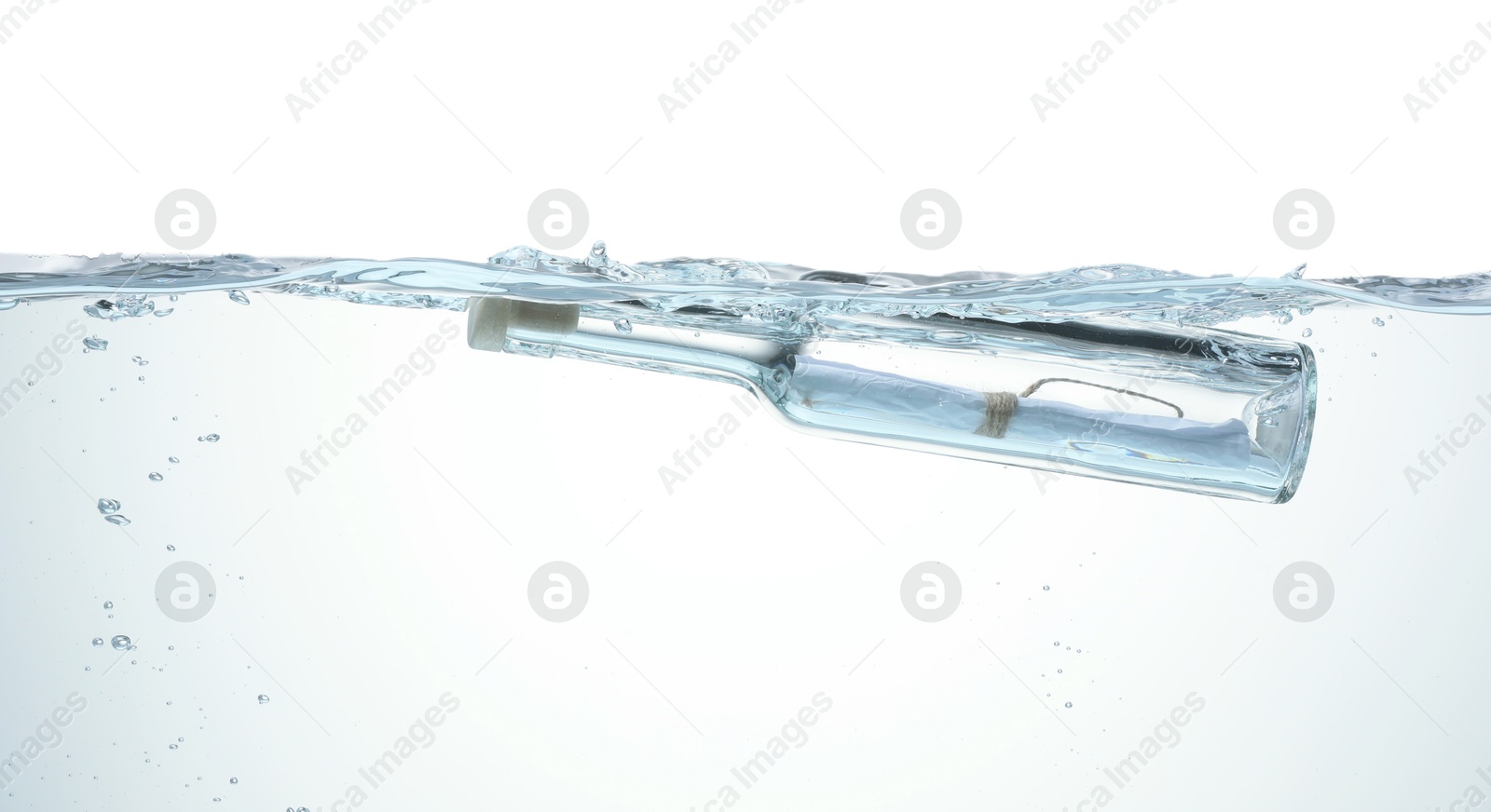 Photo of Corked glass bottle with rolled letter in water on white background