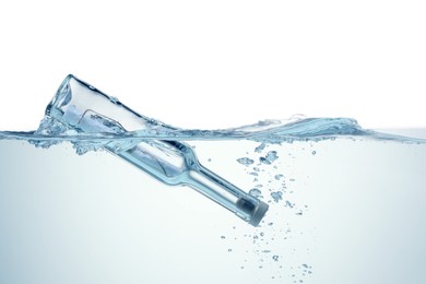 Photo of Corked glass bottle with rolled letter in water on white background