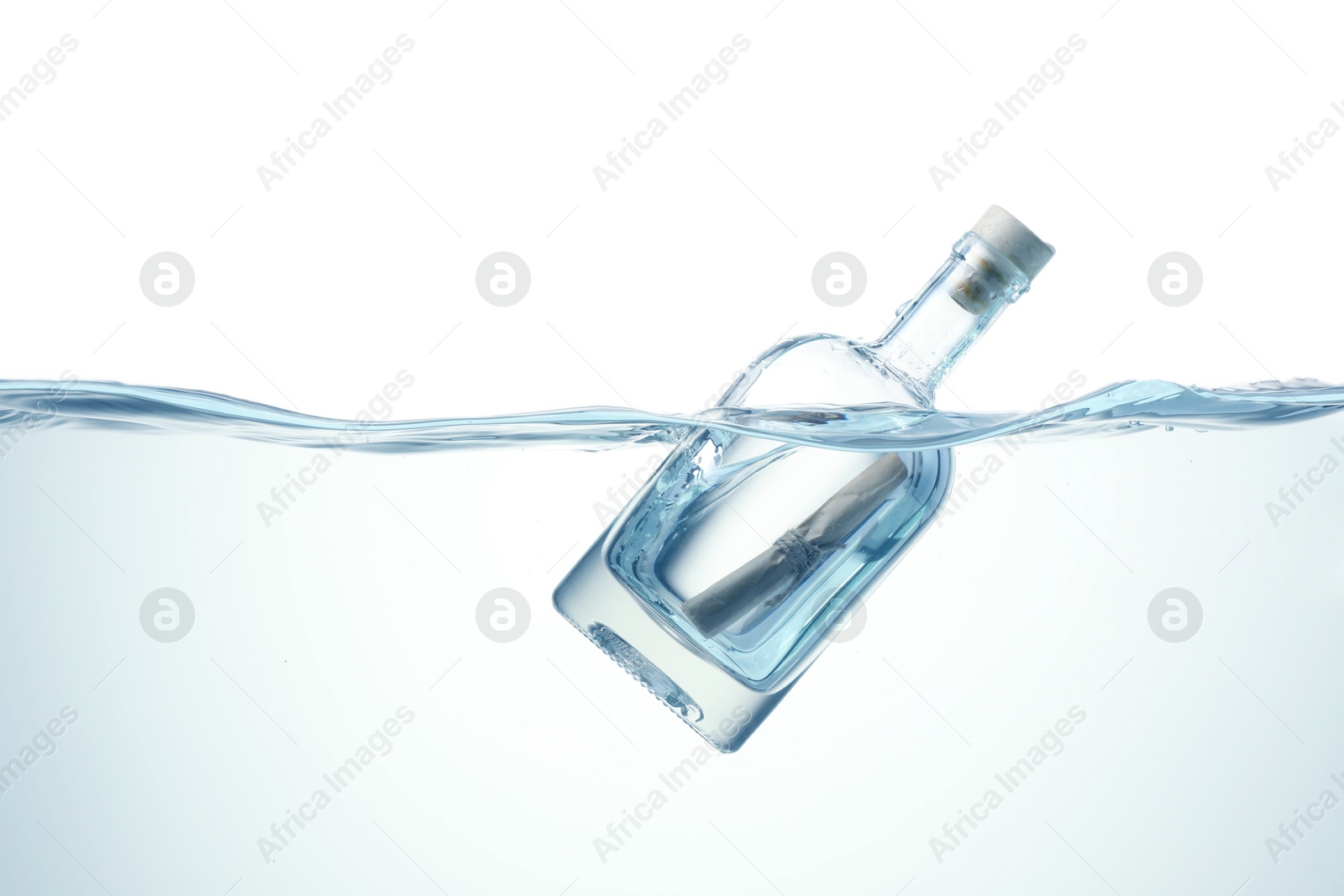 Photo of Corked glass bottle with rolled letter in water on white background