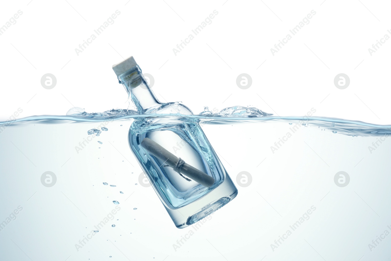 Photo of Corked glass bottle with rolled letter in water on white background