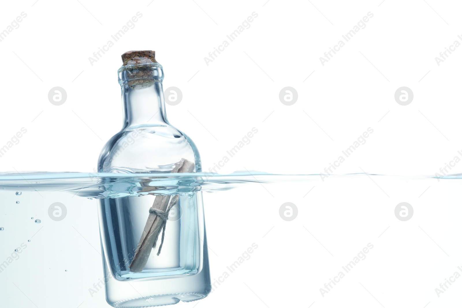 Photo of Corked glass bottle with rolled letter in water on white background