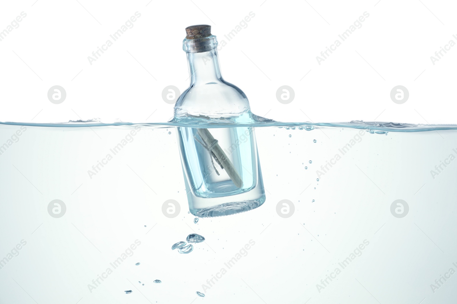 Photo of Corked glass bottle with rolled letter in water on white background