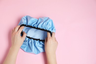 Photo of Woman with shower cap on pink background, top view. Space for text