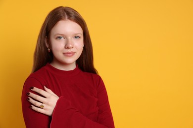 Photo of Teenage girl wearing stylish jewellery on yellow background, space for text