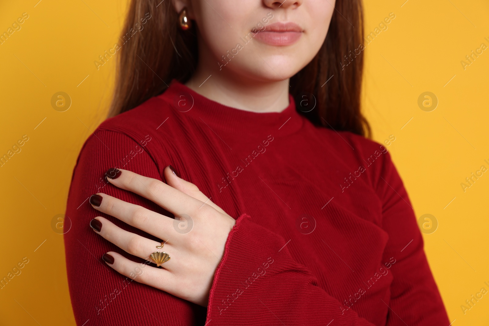 Photo of Teenage girl wearing stylish jewellery on yellow background, closeup