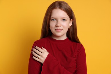 Photo of Teenage girl wearing stylish jewellery on yellow background