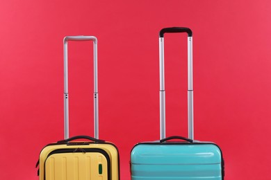 Photo of Different packed suitcases on red background. Travel luggage