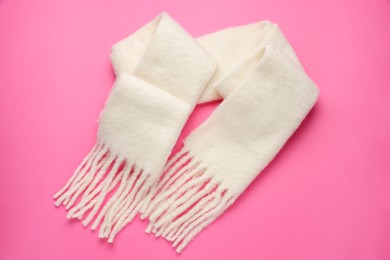 Photo of Warm woolen scarf on pink background, top view