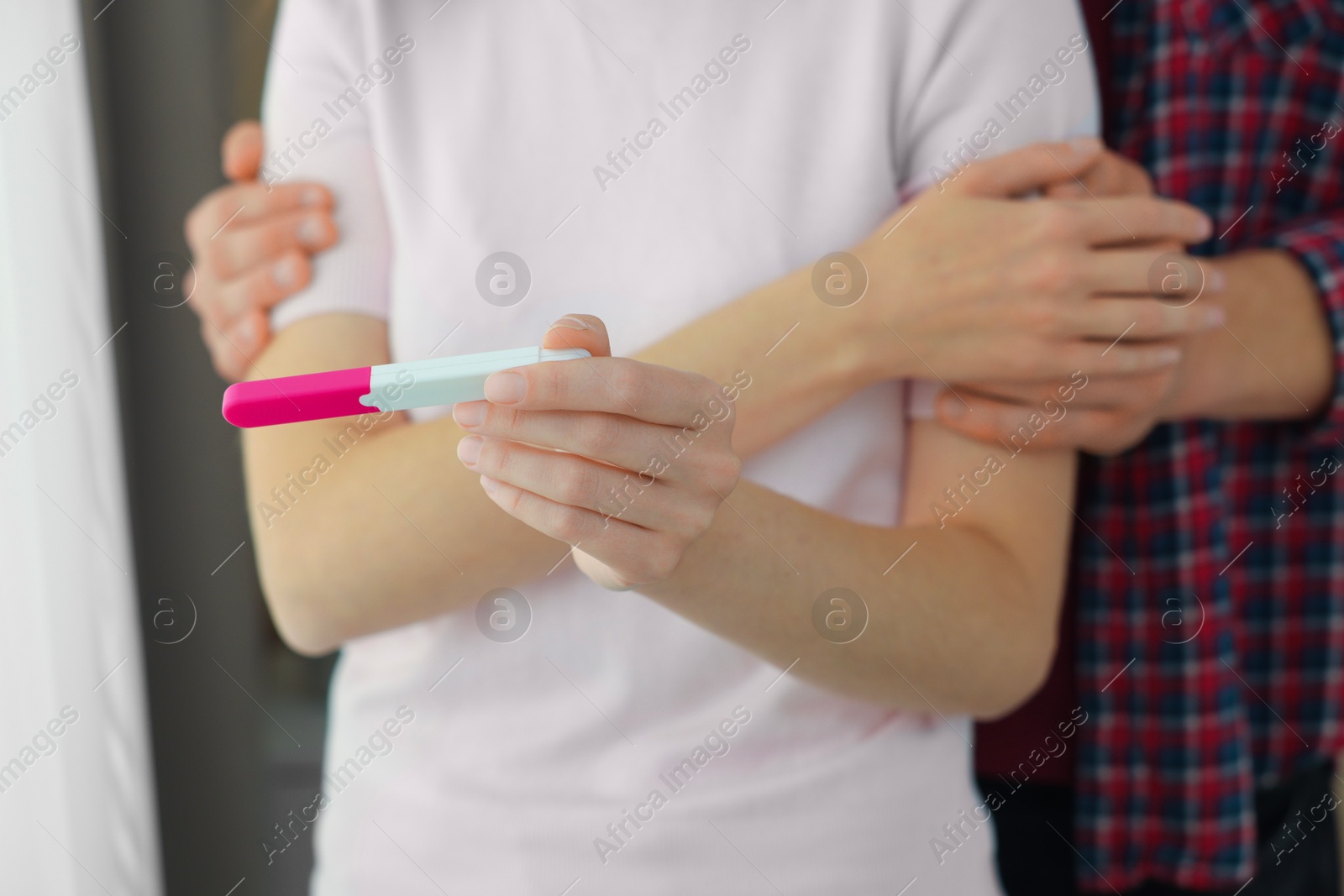 Photo of Woman with negative pregnancy test indoors, closeup. Man supporting his wife at home