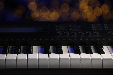 Photo of Piano against blurred lights, closeup. Bokeh effect