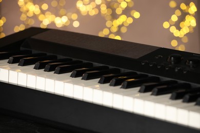 Photo of Piano against blurred lights, closeup. Bokeh effect