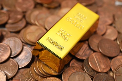 Photo of Gold bar on coins as background, closeup