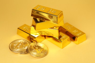 Photo of Gold bars and coins on golden background, closeup