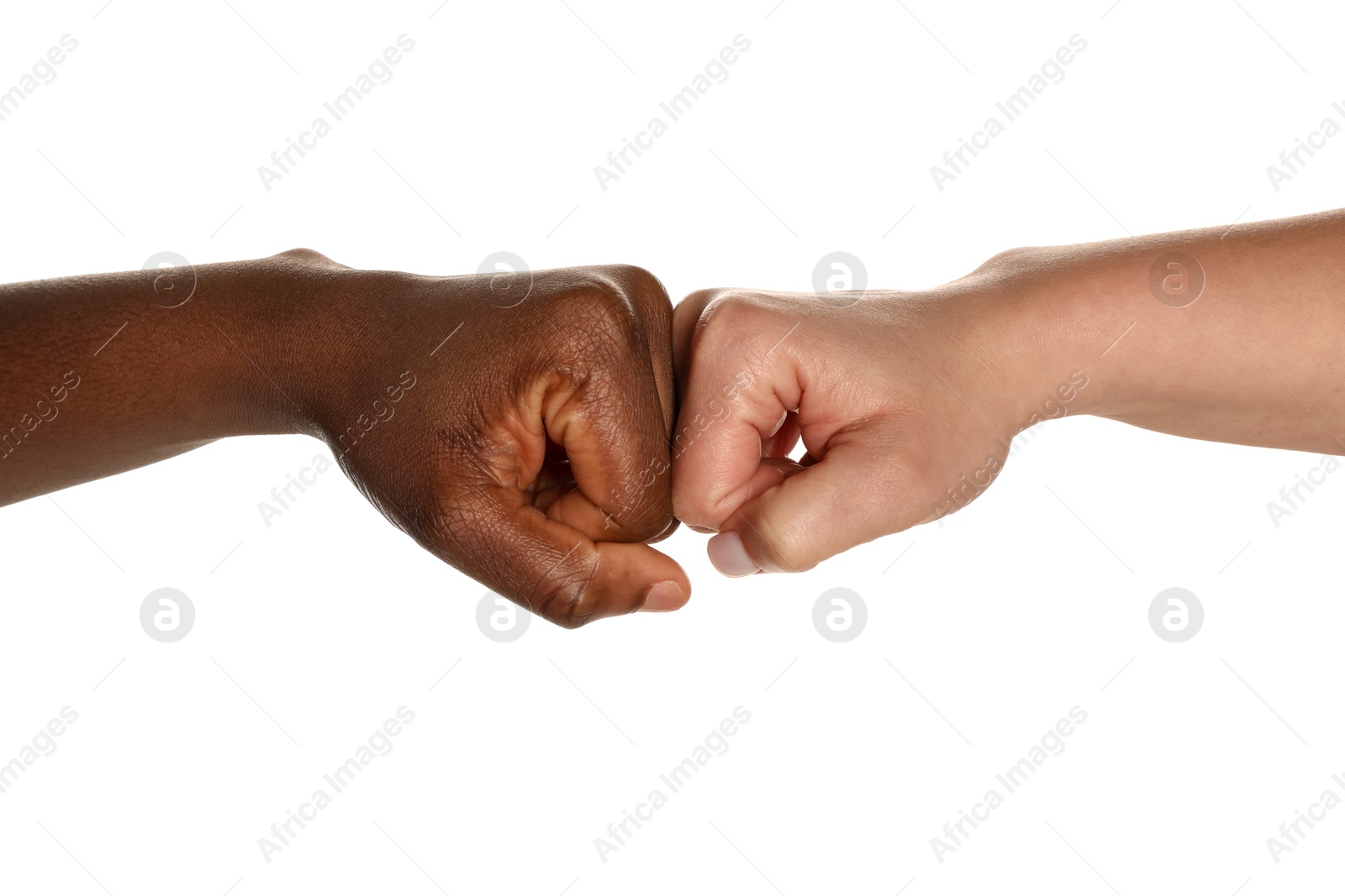 Photo of Stop racism. People of different skin colors bumping fists on white background, closeup