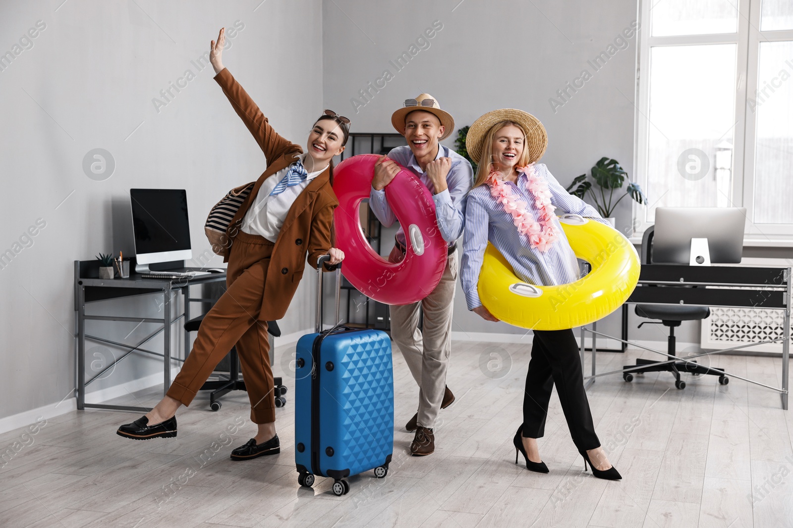 Photo of Colleagues with different beach accessories having fun in office