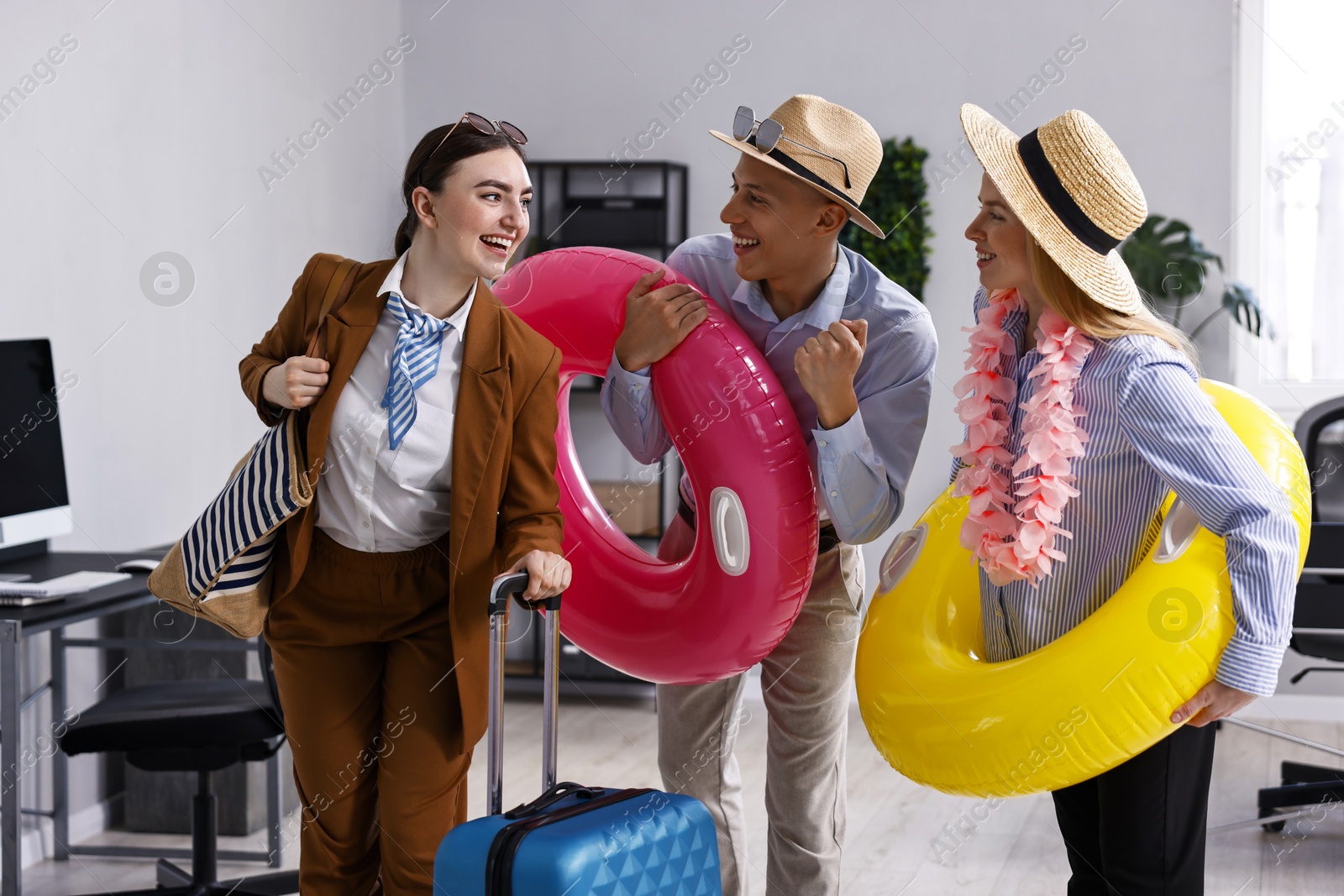 Photo of Colleagues with different beach accessories having fun in office