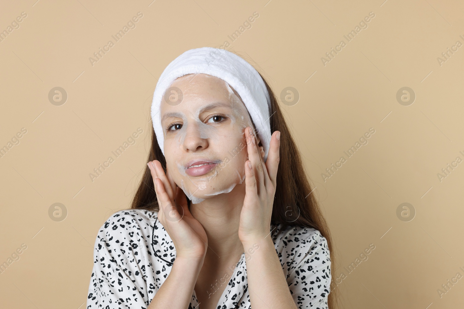 Photo of Teenage girl with sheet facial mask on beige background. Acne treatment