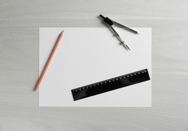 Photo of Ruler, paper, compass and pencil on white wooden table, flat lay. Space for text