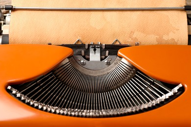 Photo of Vintage typewriter with sheet of parchment paper, closeup