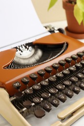Photo of Vintage typewriter with sheet of paper on white table, closeup