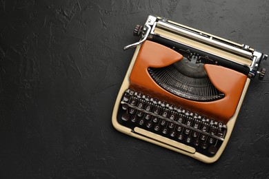 Photo of Vintage typewriter on black background, top view. Space for text