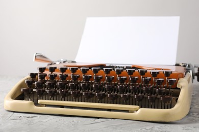 Photo of Vintage typewriter with sheet of paper on grey table