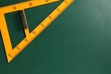 Photo of One triangle ruler on green chalkboard, top view. Space for text