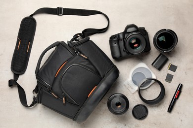 Photo of Professional photographer's equipment and case on light background, flat lay