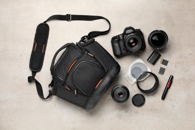 Photo of Professional photographer's equipment and case on light background, flat lay