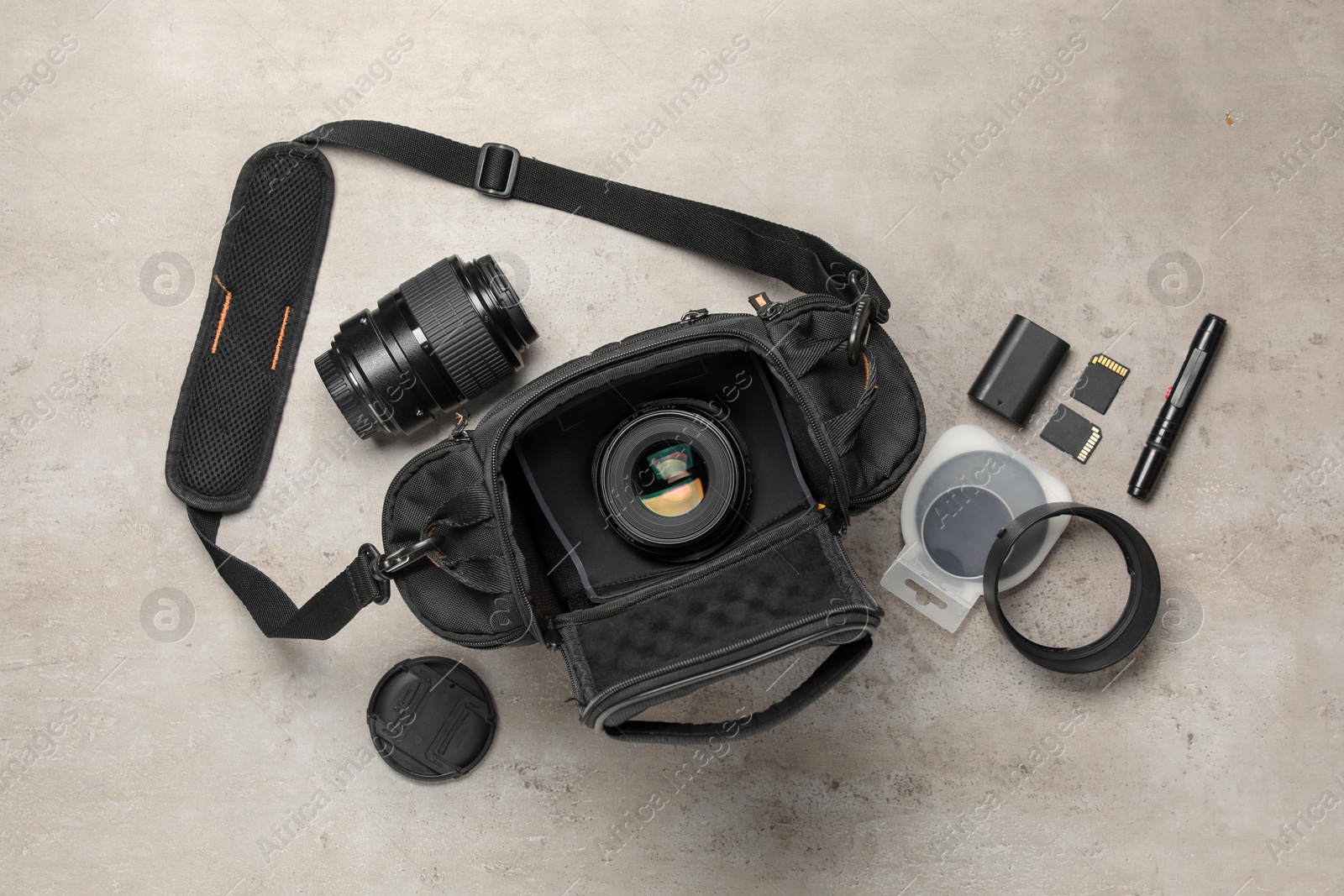 Photo of Professional photographer's equipment and case on light background, flat lay