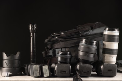 Photo of Professional photographer's equipment and backpack on light table