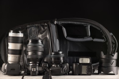 Photo of Professional photographer's equipment and backpack on light table