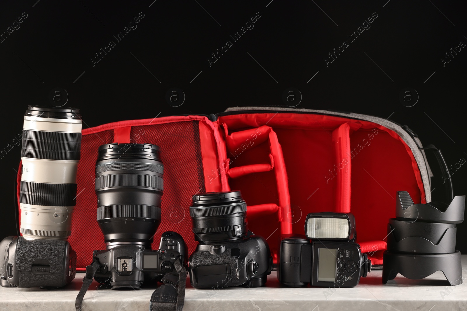 Photo of Professional photographer's equipment and backpack on light table