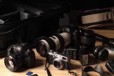 Professional photographer's equipment and backpack on wooden table