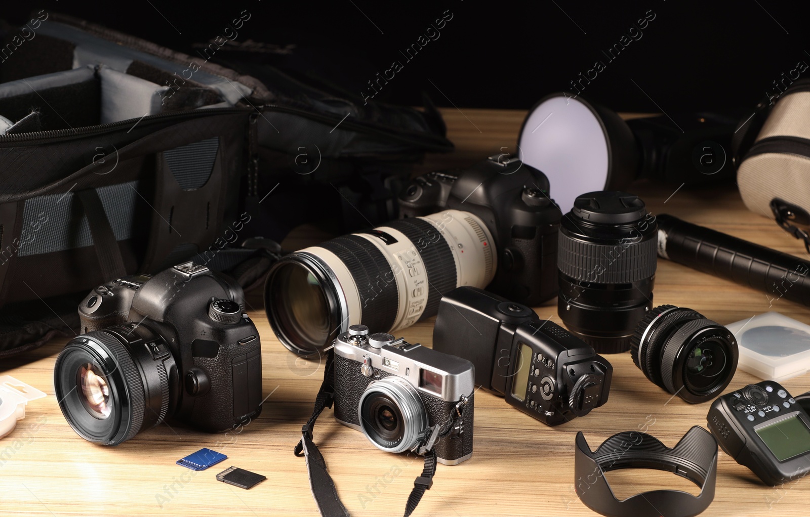 Photo of Professional photographer's equipment and backpack on wooden table