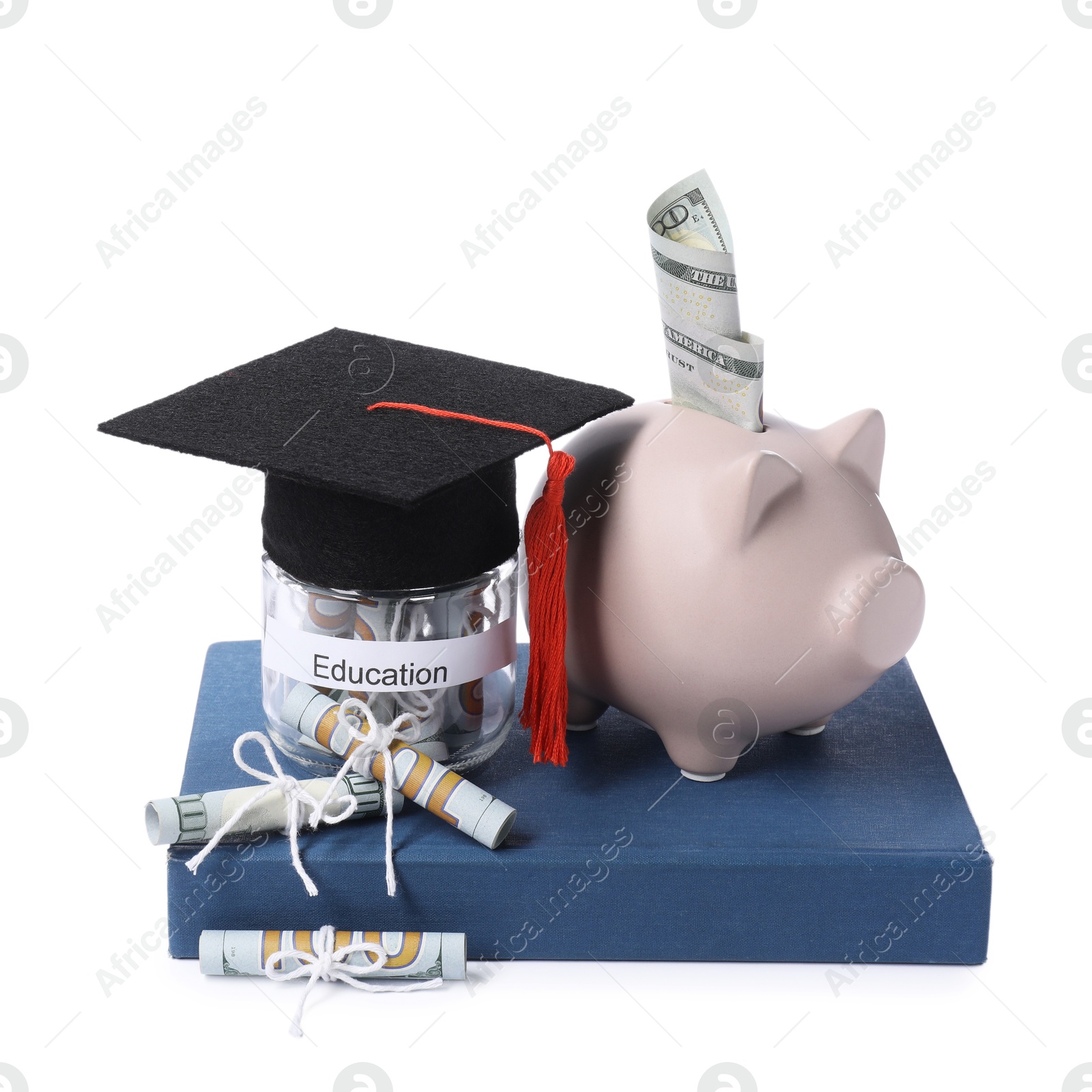 Photo of Piggy bank, graduate hat, dollar banknotes, book and glass jar with word Education isolated on white. Tuition payment