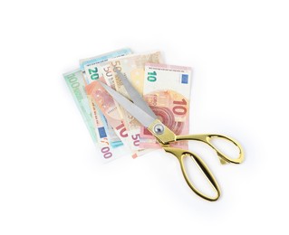 Euro banknotes and scissors isolated on white, top view