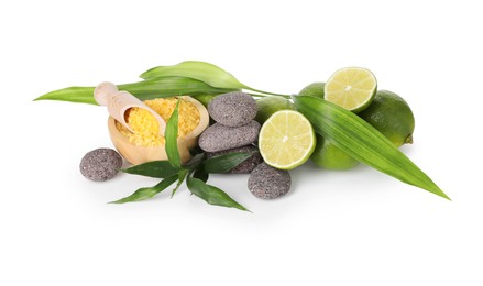 Photo of Spa composition with limes, massage stones, sea salt and green leaves isolated on white