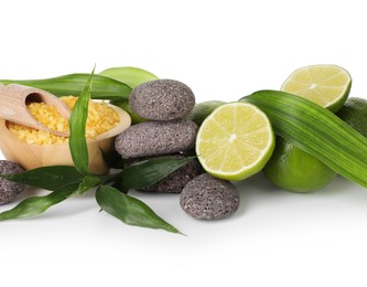 Photo of Spa composition with limes, massage stones, sea salt and green leaves isolated on white