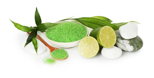 Photo of Spa composition with fresh limes, sea salt, massage stones and bamboo leaves isolated on white