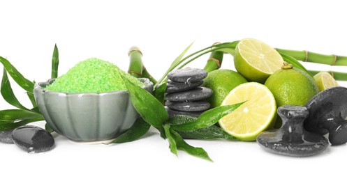 Photo of Spa composition with fresh limes, sea salt, massage stones and bamboo isolated on white