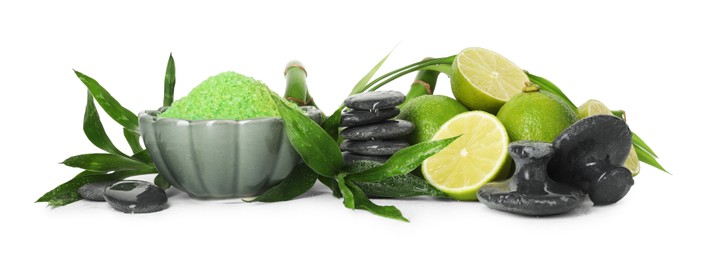 Photo of Spa composition with fresh limes, sea salt, massage stones and bamboo leaves isolated on white